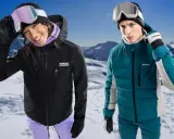 Para narciarzy w górach. Ona w czarnej kurtce hardshell, on w turkusowej kurtce softshell.