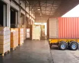 Almacén con camión y contenedores listos para la normativa de carga y descarga de camiones.