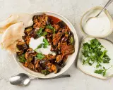 Délicieuse recette aubergine viande hachée, servie avec du pain pita, une cuillère de yaourt et du persil frais.