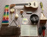Kolorowy ksylofon, ukulele, tamburyn, marakasy, harmonijka, trójkąt, bębenek, CD, słuchawki, metronom, kalimba, nuty, mikrofon i pilot. To najprostszy instrument do nauki.