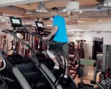 Mann trainiert auf einem Stairmaster im Fitnessstudio.