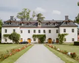 Piękna dolina pałaców i ogrodów z białym budynkiem, zielonym trawnikiem i kwitnącymi kwiatami.