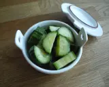 Snabbsaltad gurka i en vit skål, redo att serveras. Enkel och god tillbehör.