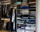 Un dressing bien organisé : vêtements pliés et suspendus, chaussures rangées. Idéal pour savoir comment organiser son dressing.