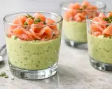 Verrine avocat saumon : une couche crémeuse d'avocat et d'herbes surmontée de fines tranches de saumon fumé, garnie d'aneth.
