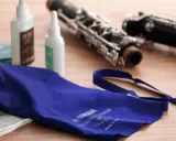 Ensemble pour l'entretien d'une clarinette : deux flacons d'huile, une housse bleue et des parties de l'instrument.