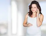 Gravid kvinna med orolig min ringer om sina Braxton Hicks sammandragningar.