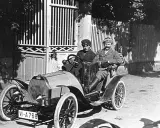 Zwei Männer in einem Bugatti, der aus Molsheim stammt, fahren durch eine sonnige Straße.