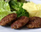 Drei gebratene Fleischpflanzerl mit Kartoffelbrei und Salat. Ein leckeres Fleischpflanzerl Rezept für zu Hause.