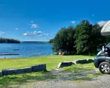Husbil vid en sjö med brygga och gräsmatta. Perfekt för fricampa Sverige.