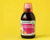 Botella de líquido quemagrasas con etiqueta rosa y naranja sobre fondo amarillo.