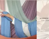 A hand drapes light blue fabric, suggesting the best clothing material for summer is breathable and cool.