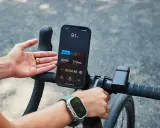 Rowerzysta sprawdza na telefonie, co oznacza puls 91. Na ekranie widać tętno 113 BPM i czas treningu.