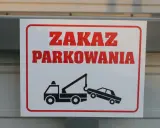 Zasady parkowania na parkingu: zakaz parkowania, holowanie pojazdów. Znak ostrzega przed odholowaniem źle zaparkowanego auta.