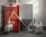 Nowoczesny piec na pellet Stalmark z zasobnikiem i workiem pelletu. Idealny, by wybrać, jaki piec na pellet do domu 120m2 zapewni ciepło.