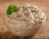 Pyszna pasta z tuńczyka w szklanej miseczce, posypana pieprzem i udekorowana natką pietruszki. Idealna na kanapki.