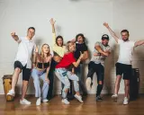 Grupa ludzi wesoło pozuje, gotowa do tańca zouk.