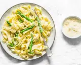 Pyszny makaron ze szparagami w kremowym sosie, posypany parmezanem. Idealny na wiosenny obiad.