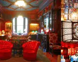 The National Arts Club features opulent interiors with red velvet chairs, ornate woodwork, and a stunning stained-glass ceiling.