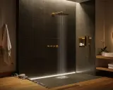 Un'elegante doccia muratura senza vetro, con finiture dorate e un soffione a pioggia. L'illuminazione soffusa crea un'atmosfera rilassante.