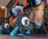 Intensywna jazda na rowerze w domu. Kilka rowerów stacjonarnych z trenażerami w akcji, tworząc wrażenie ruchu.
