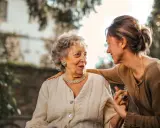 Un legame forte tra madre e figlia adulta, un abbraccio che simboleggia la dipendenza dalla madre in età adulta, ma anche amore e cura.