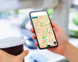 Persona usa un app cargadores eléctricos en su móvil para encontrar puntos de recarga en un mapa.