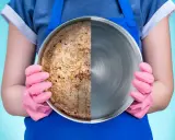 Una padella in acciaio divisa a metà: da un lato incrostata e sporca, dall'altro lucida e pulita.