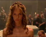 Die schöne Helena, Menelaos' Frau, blickt ernst in die Menge. Ihr Haar ist kunstvoll geflochten, ein goldenes Halsband schmückt ihren Hals.