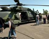 Besucher bestaunen deutsche Hubschrauber auf einem Flugplatz.