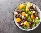 Salade de gésiers savoureuse avec pommes de terre rôties, croûtons et salade verte fraîche. Un délice pour les amateurs de cuisine française.