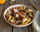 Salade de pommes de terre et hareng, garnie d'olives noires, de tomates séchées et d'oignons rouges. Un plat savoureux et coloré.