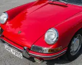 Roter Porsche 901, ein Klassiker mit hohem Wert. Die Front zeigt das Porsche-Logo und die Kennzeichenplatte "EARLY 911S".