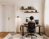 Un espace de travail épuré, avec une personne assise à son bureau, créant le bureau idéal.