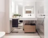Baño moderno con lavabo flotante, mueble de madera y plantas. Ideal para quienes buscan reformar baño precio.