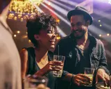 Coppia felice ride e beve in un locale notturno di Barcellona, tra luci soffuse e musica.