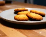 Assiette de sablés fondants au beurre, dorés et appétissants, sur un fond en bois.