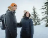 Para zimowa, czyli kurtka parka, to idealny wybór na mroźne dni. Para w ciepłych kurtkach cieszy się zimowym krajobrazem.