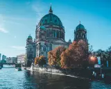 Berliński Dom, idealne miejsce na city break. Rzeka Szprewa, łodzie i jesienne drzewa tworzą malowniczy widok.