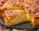 Ein goldbrauner Apfelkuchen mit Zimtstreuseln, der Lust auf tolle Apfelkuchen Rezepte macht. Ein Stück wird gerade herausgehoben.