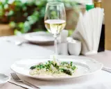 En krämig risotto med sparris och örter, perfekt ackompanjerad av ett glas vitt vin till risotto.