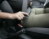 Persona abrochando el cinturón de seguridad. Recuerda, el cinturón de seguridad debe ir siempre abrochado para tu protección.