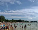 Tłumy ludzi korzystają z kąpieliska w Skorzęcin, ciesząc się słońcem i wodą. To popularne miejsce oferuje wiele atrakcji dla każdego.