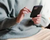 Dłonie piszą sms po kłótni, próbując załagodzić sytuację.