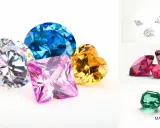 Un arcobaleno di gemme: un diamante rosa quadrato, uno zaffiro blu rotondo, un diamante giallo a forma di cuore e un diamante bianco sfaccettato.