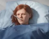 En sjuk flicka med febertermometer i munnen. Tänk på att vaccinera influensa för att undvika detta.