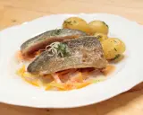 Zartes Forellenfilet braten, serviert mit kleinen Kartoffeln und julieniertem Gemüse in einer leichten Sauce. Ein Genuss!