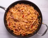 Fideuà de marisco en paellera, con fideos finos, calamares y pimientos rojos. ¡Perfecta para aprender como hacer fideuà!