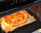 Une pizza maison dorée et appétissante cuit dans un four, prête à être dégustée. Une parfaite recette pizza au four.