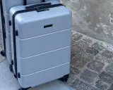 Två grå resväskor, perfekta som lufthansa handbagage, står på en kullerstensbelagd trottoar.
